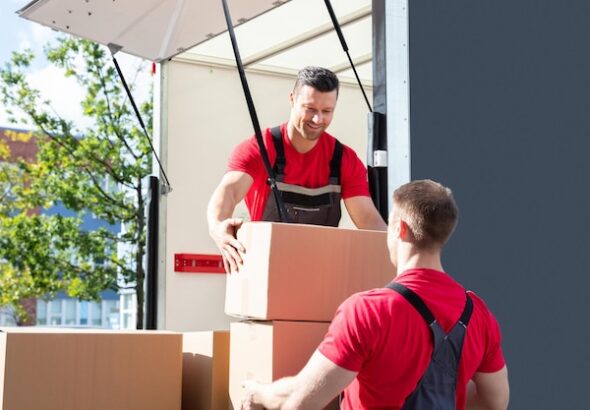 two-male-worker-loading-cardboard-boxes-moving-truck_1016675-728