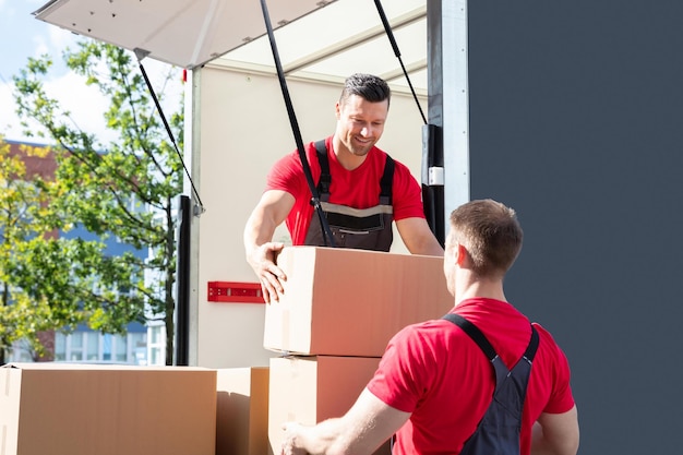 two-male-worker-loading-cardboard-boxes-moving-truck_1016675-728