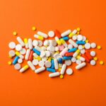 different-pills-orange-table-top-view-min