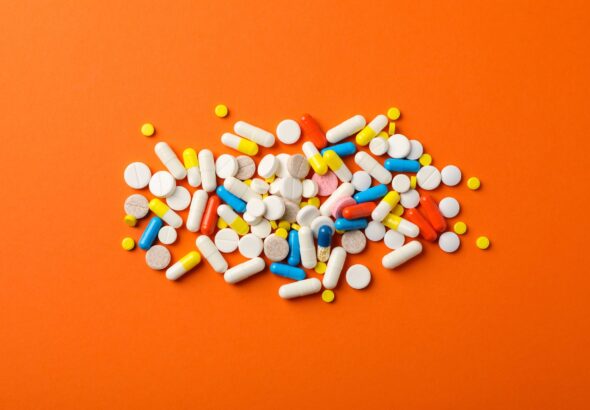different-pills-orange-table-top-view-min
