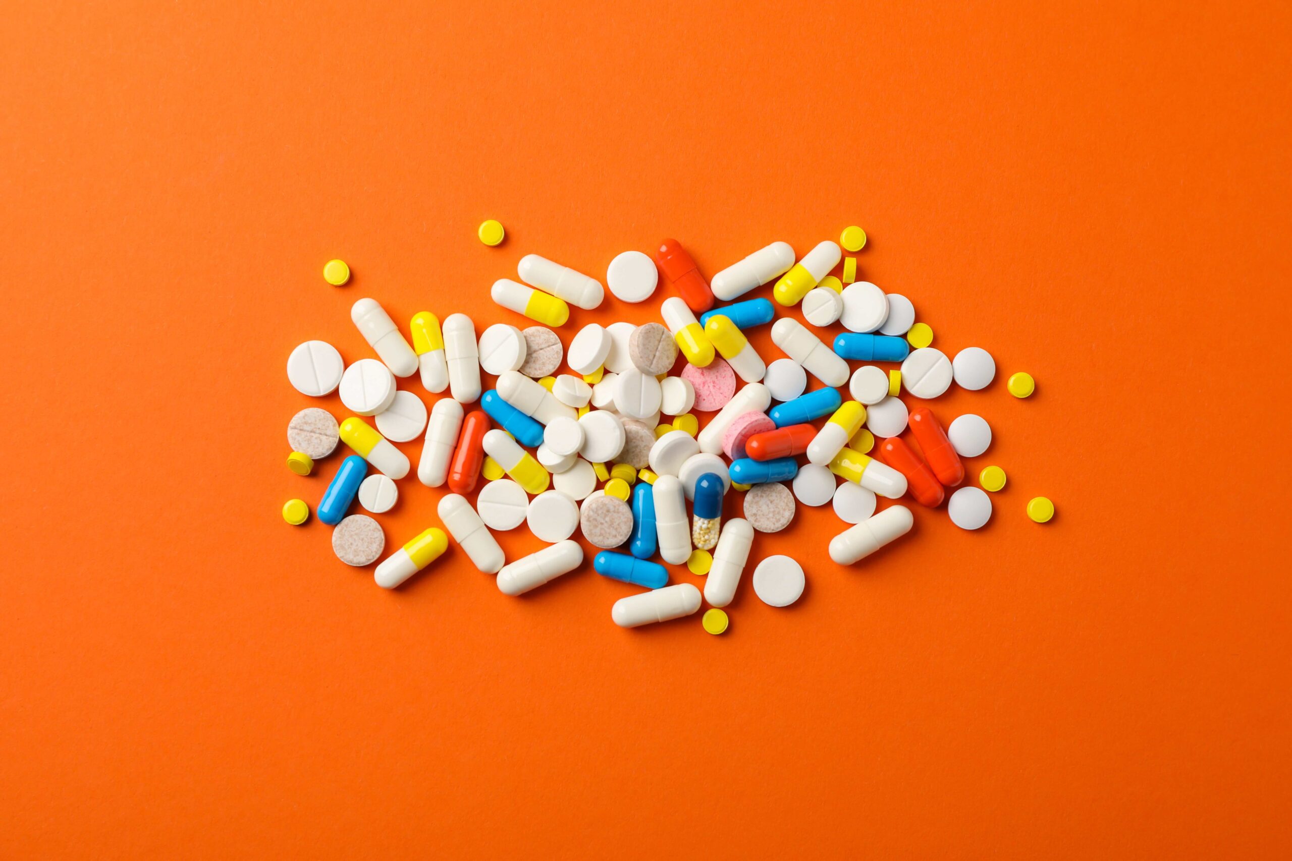 different-pills-orange-table-top-view-min