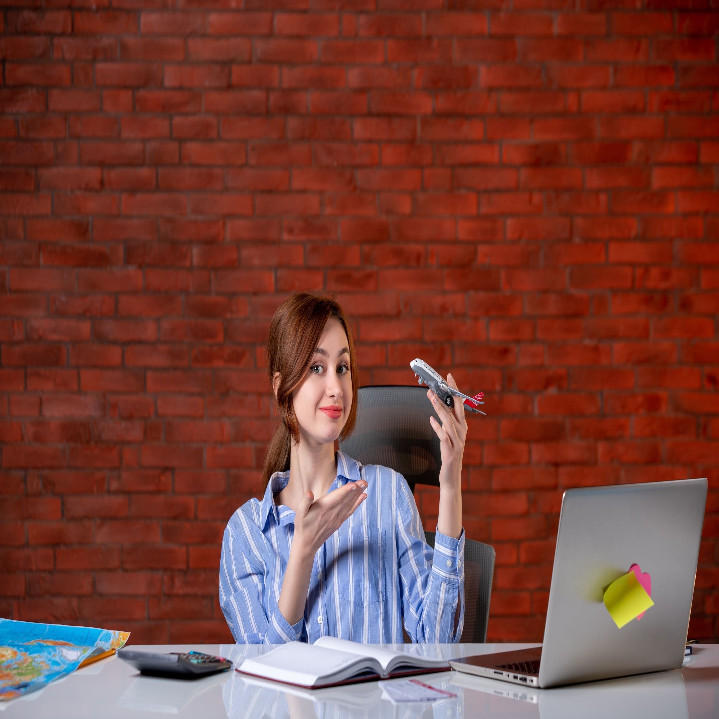 front-view-travel-agent-sitting-her-working-place-holding-toy-plane-agency-service-world-operator-assistant-map-global-ticket-managers-1