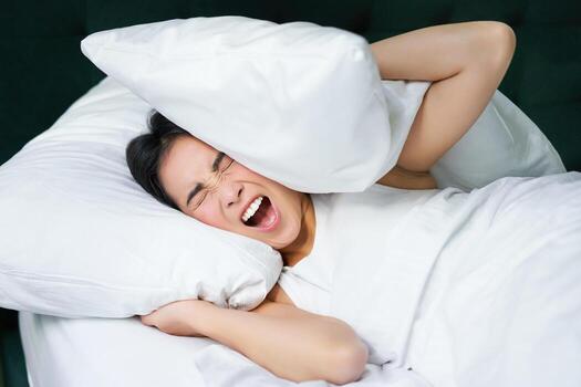 sad-girl-with-insomnia-young-asian-woman-lying-in-bed-cover-her-ears-with-pillow-cant-sleep-partner-snors-loud-noise-at-night-disturbing-her-free-photo-1