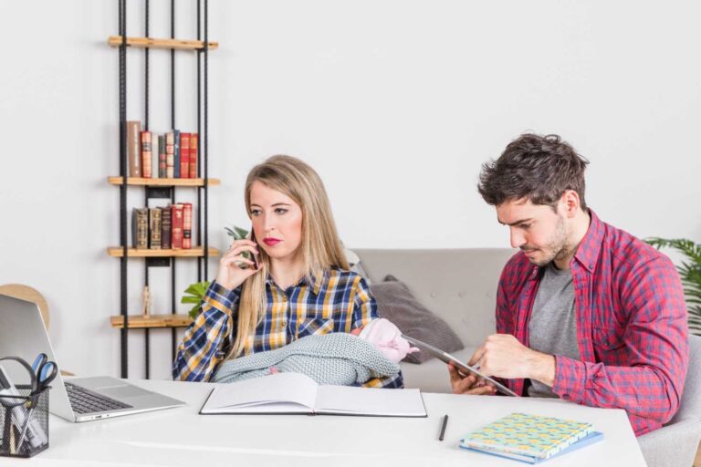 mother-with-baby-talking-phone-while-father-using-tablet-1